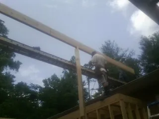 Carpenter setting a ridge beam over a new addition frame — Ice Dam Removal by Roofing Brothers in Gwynedd