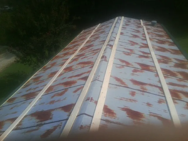 Rusted metal roof panels with new wood purlins before replacement — Storm Damage Roof Repair in Gwynedd by Roofing Brothers