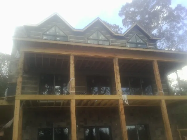 Dormers and porch framing on a large log home under construction — Roof Coating work by our crew in Gwynedd