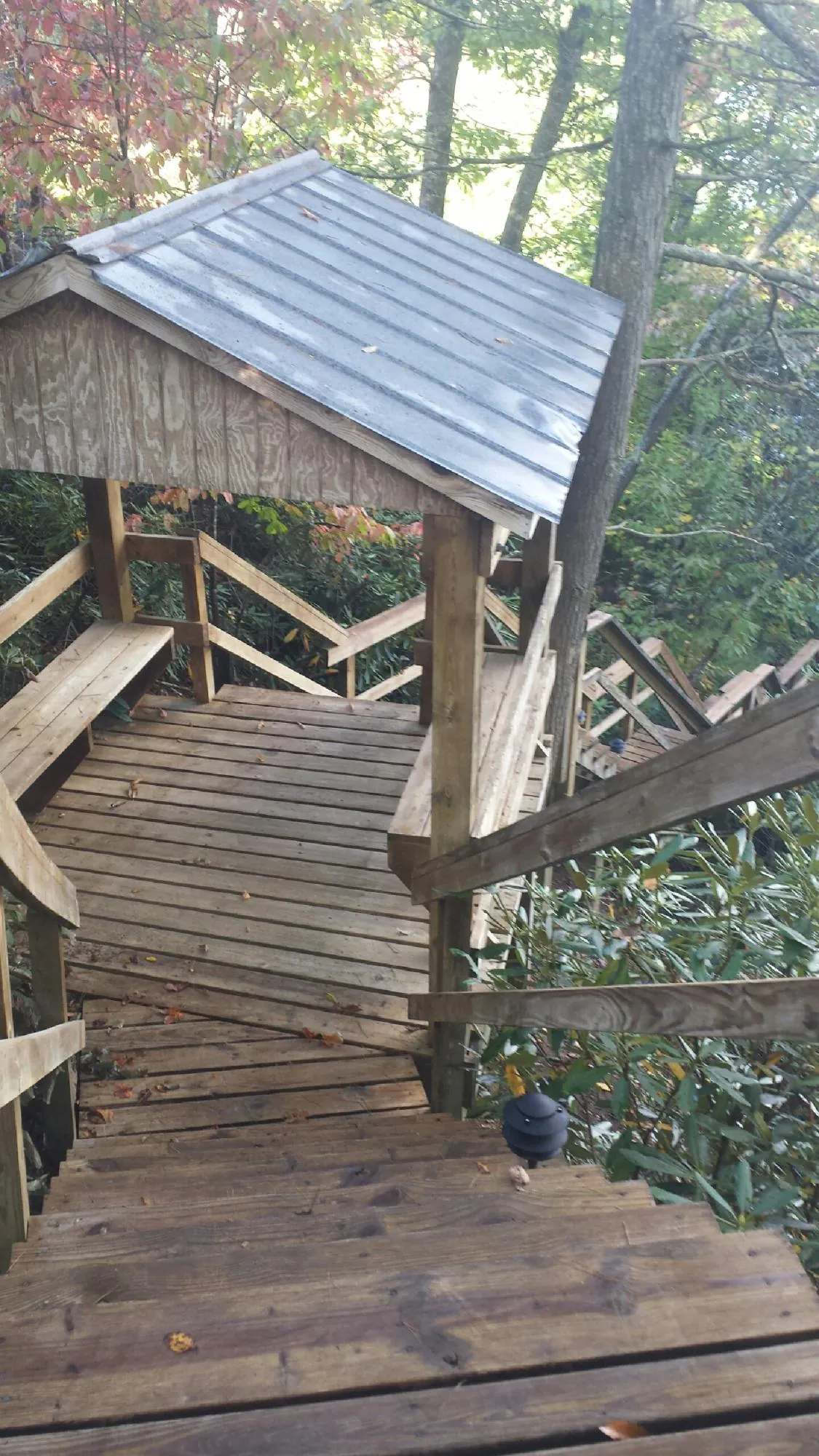 Metal roofed shelter over wooden steps on a wooded walkway — Skylight Repair & Installation work by our crew in Gwynedd